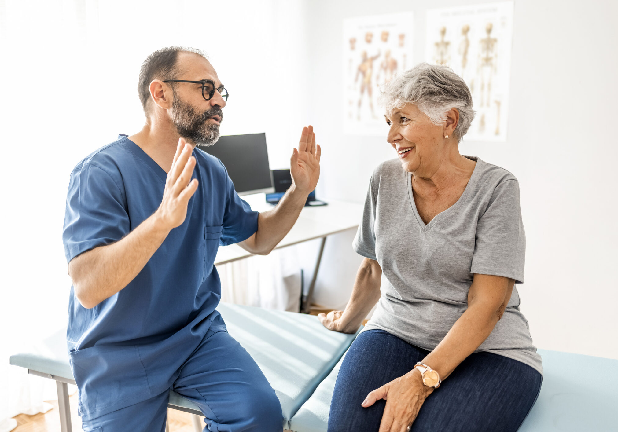 Clinician conducting a medical assessment consultation with an adult patient in a clinical setting